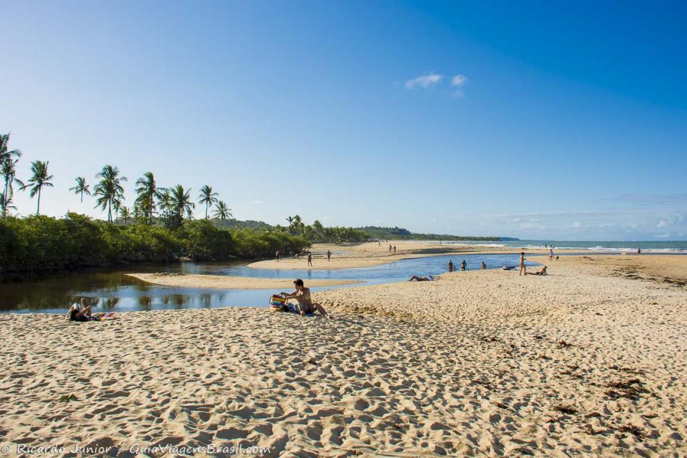 Imagem de pessoas em volta da piscina natural da Praia dos Coqueiros.